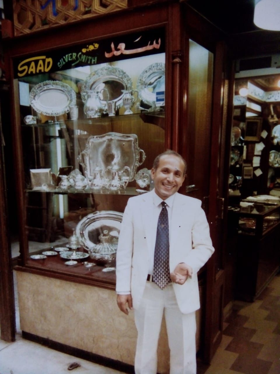 Vintage portrait of the founder of Saad of Egypt standing in front of the original silver boutique showcasing handcrafted Egyptian silverware and heritage luxury gift collections.