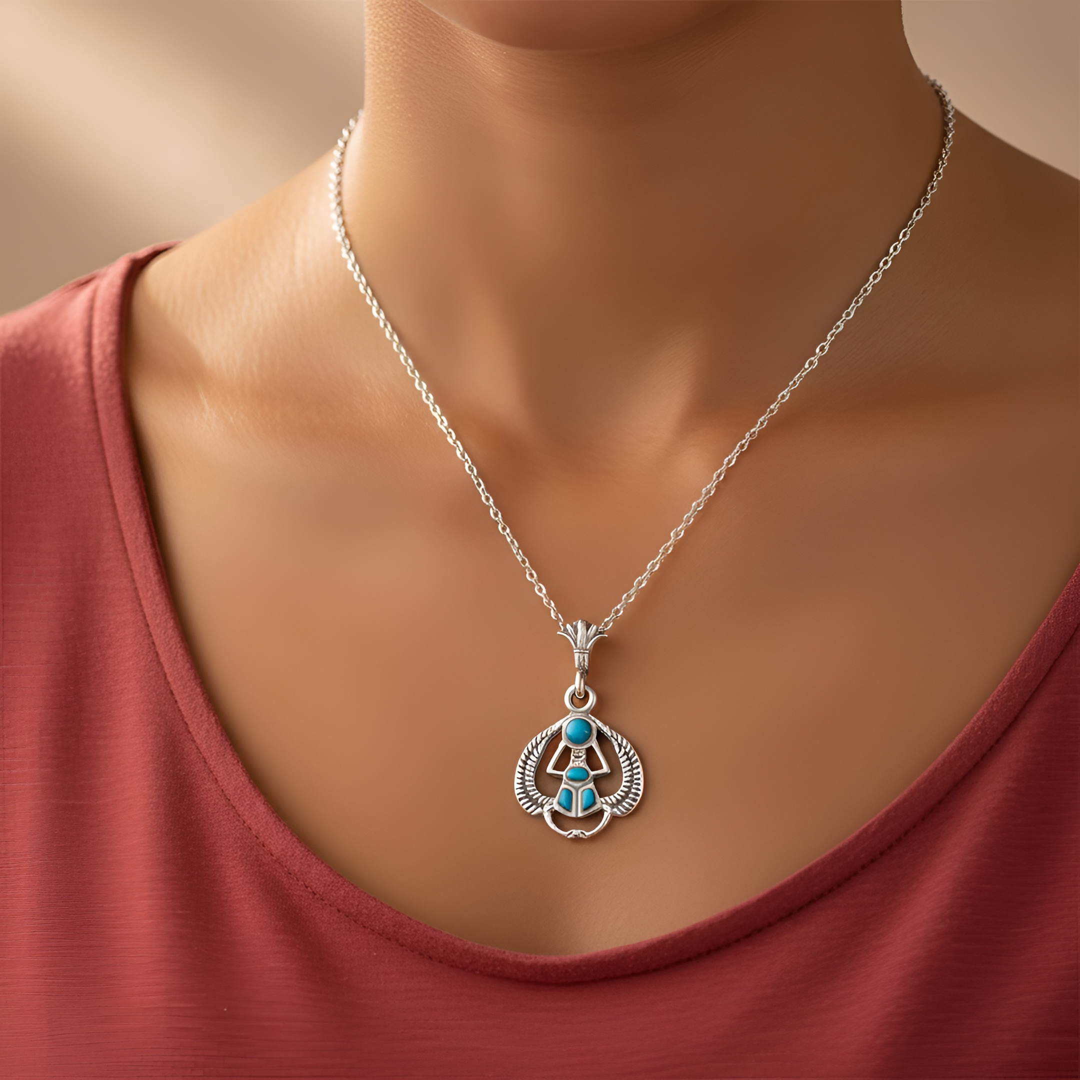 Close-up image of a woman wearing a handcrafted 925 sterling silver flying scarab turquoise pendant, an elegant women’s jewelry gift by Saad of Egypt